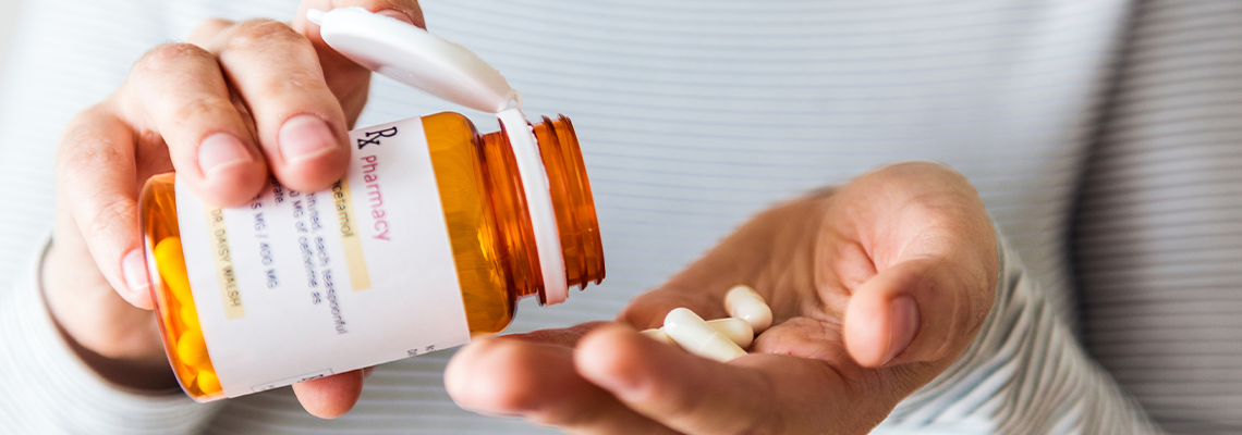 Sick woman taking pills from bottle
