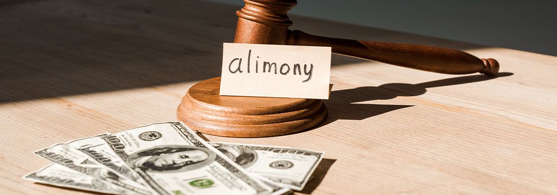 Gavel near dollar banknotes and paper with alimony
