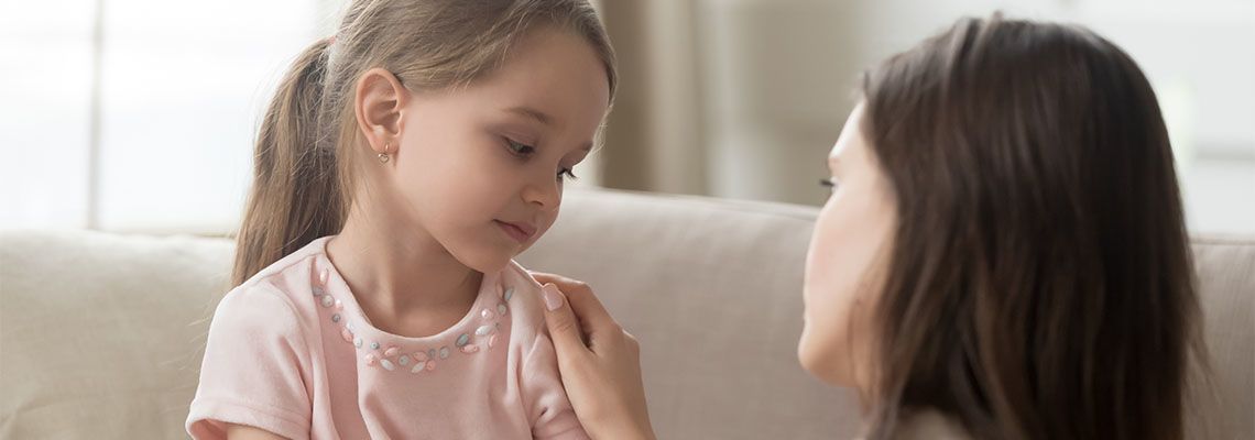 Loving mom talking to upset little child girl