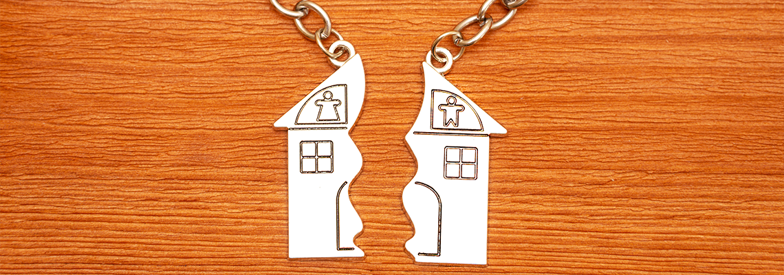 Keys with split house keychains on a wooden table