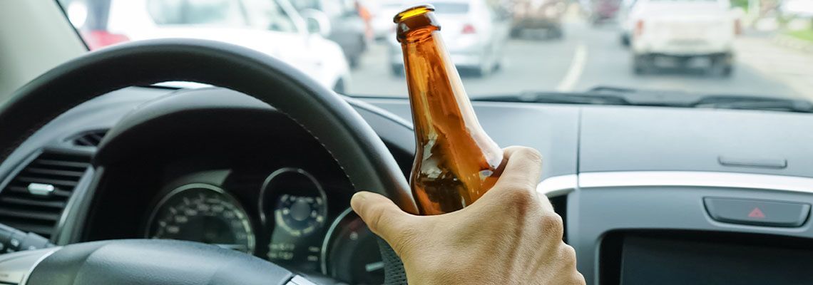 A driver holding alcoholic bottle while driving
