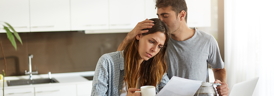 Frustrated Woman Studying Bankruptcy Paper in Kitchen with Husband