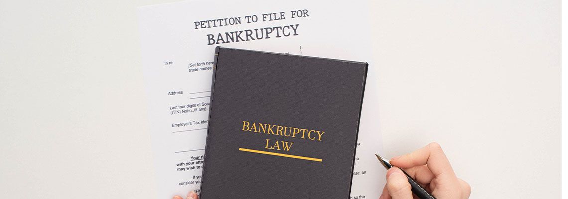 Bankruptcy paper and law book on white background