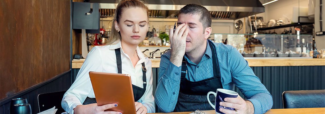 Worried business owners calculating finances