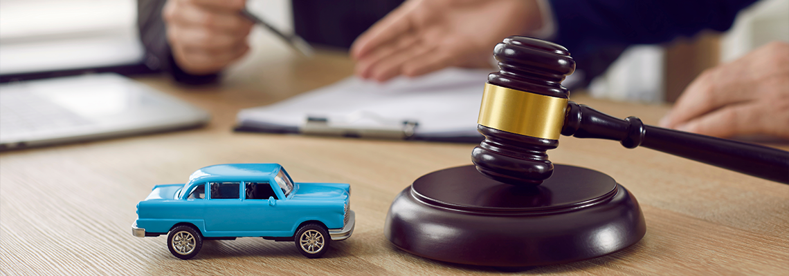 Judge gavel and miniature car symbolize auction or court case