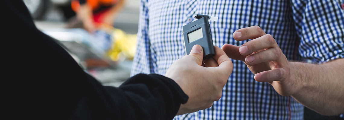 Policeman administering a breathalyzer test.