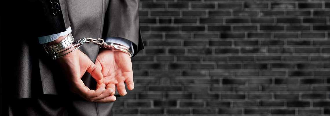 Cropped image of person with hands in handcuffs behind back