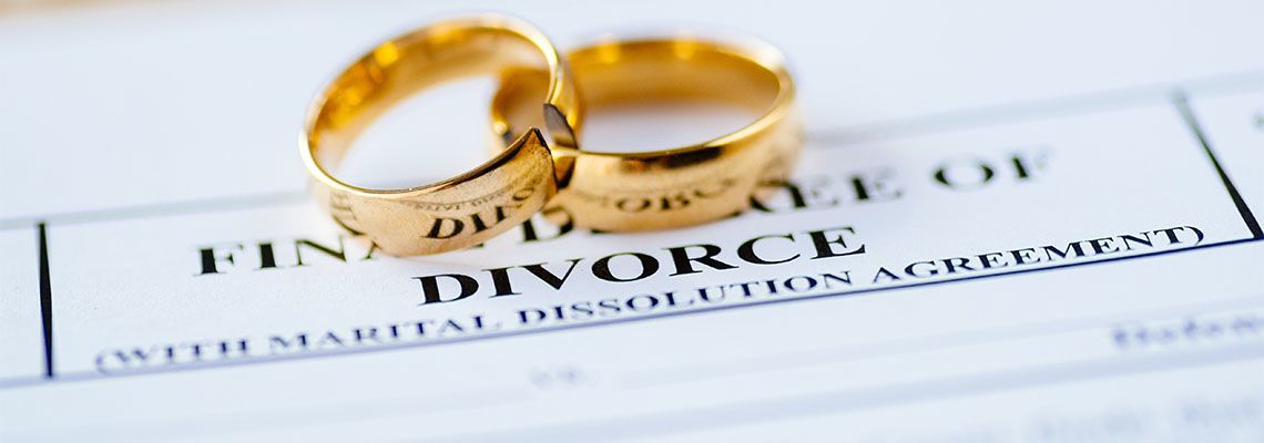 Two broken golden wedding rings divorce decree document