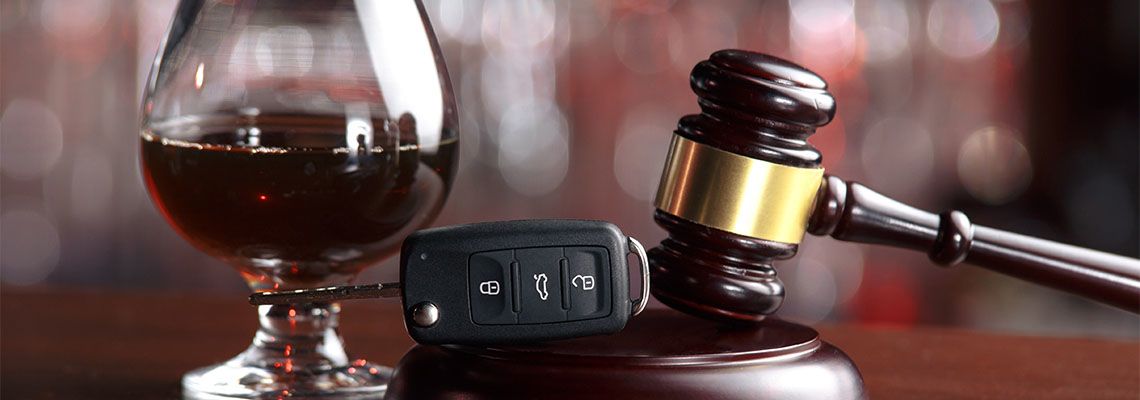 Law hammer, alcohol and car keys on wooden table