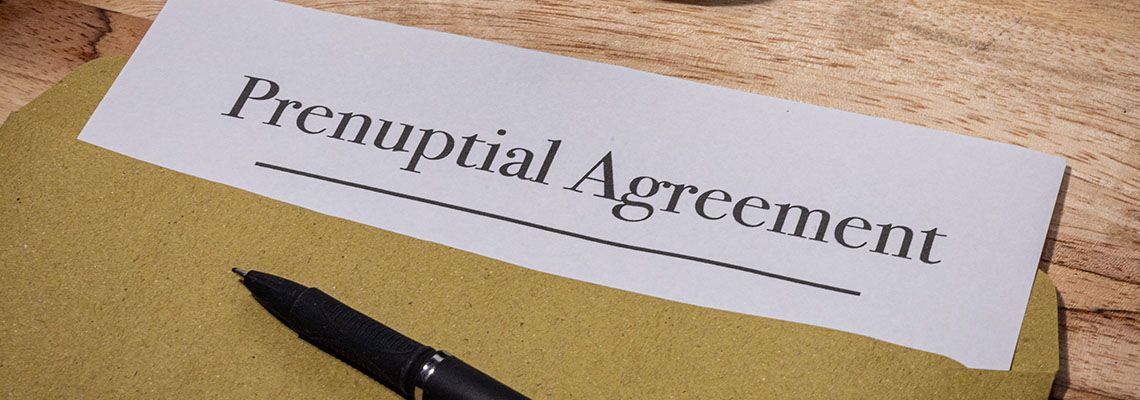 Prenuptial Agreement Document Resting on Wooden Desk