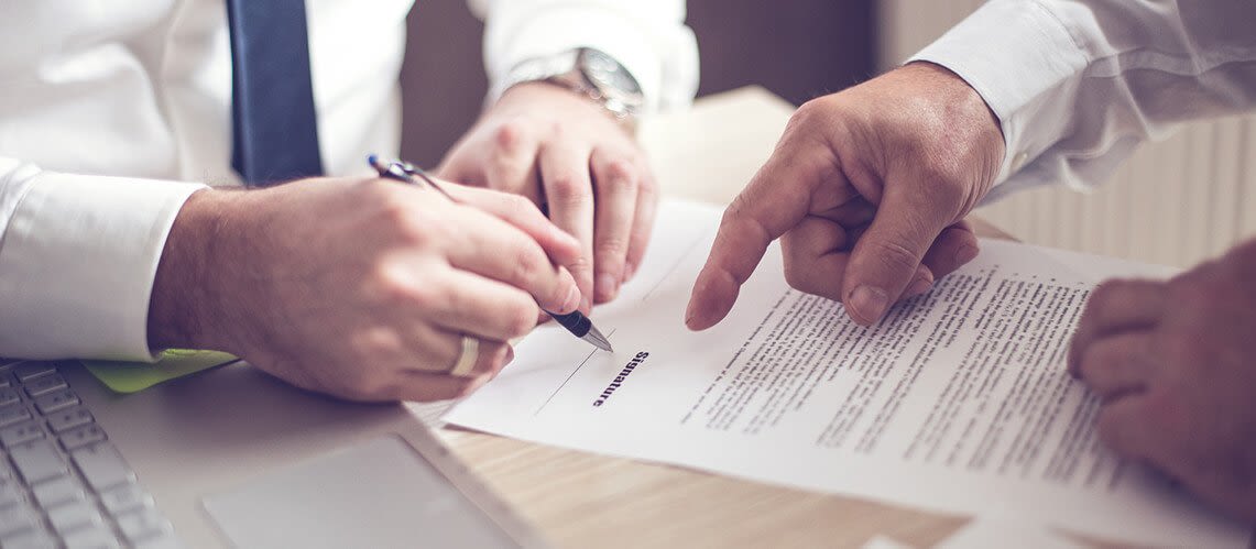 Two sets of hands looking over a contract