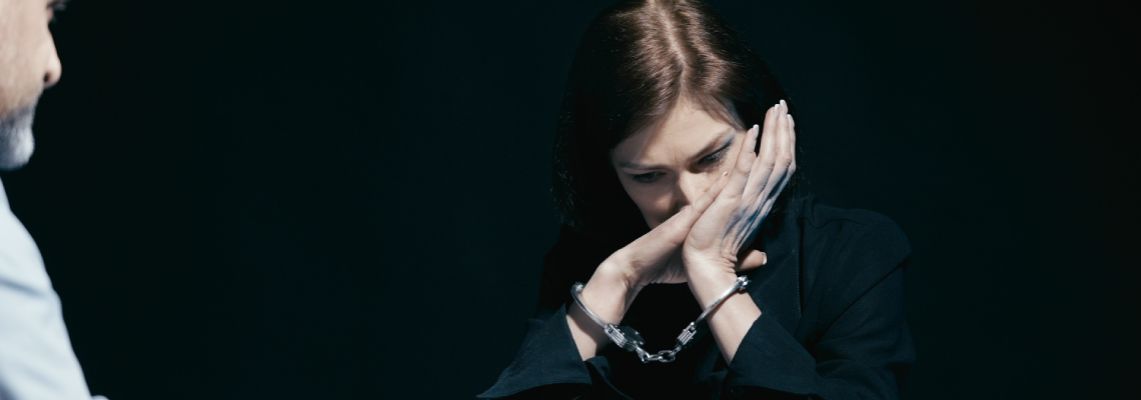 Distressed woman in handcuffs sobs in front of the police