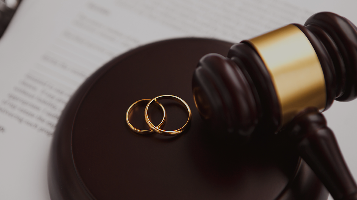 A gavel next to two wedding rings