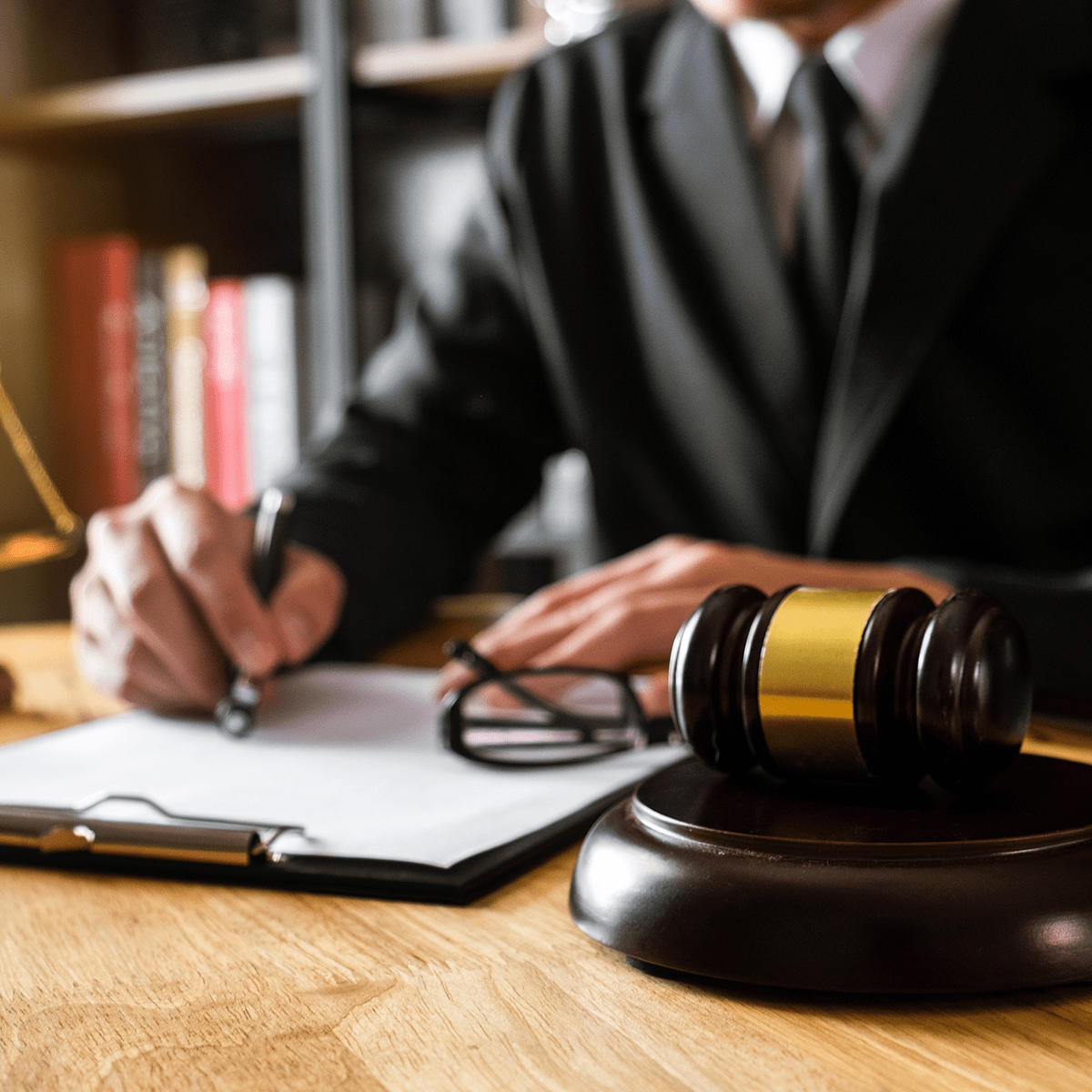 justice and law concept.Male judge in a courtroom the gavel, working with smart phone and laptop and digital tablet computer on wood table in morning light