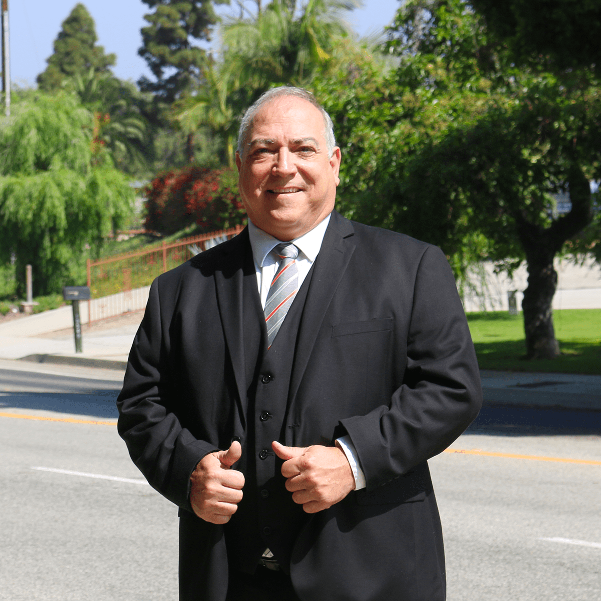 old man, wearing suit, smiling, trees in background