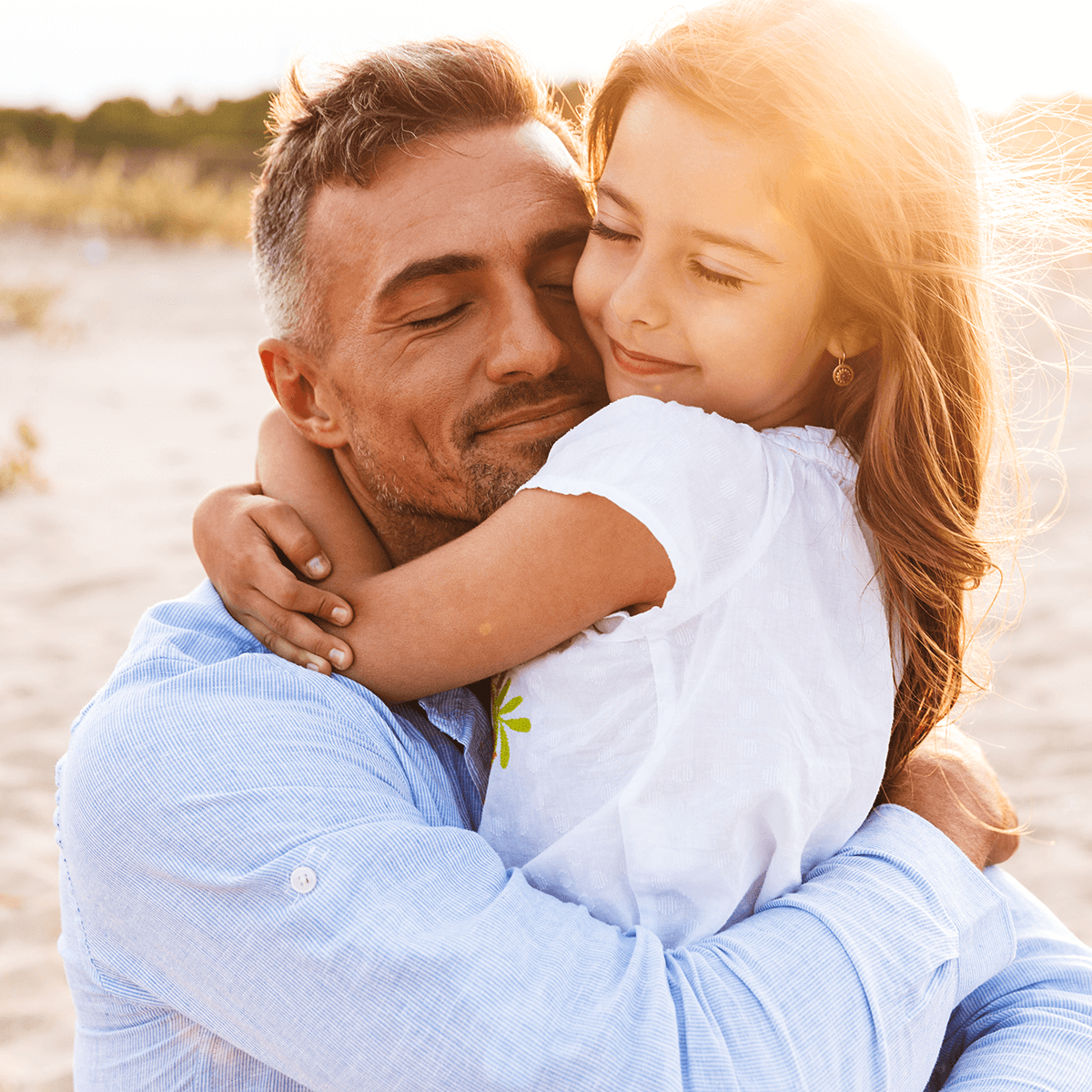 Father hugging daughter on the beach