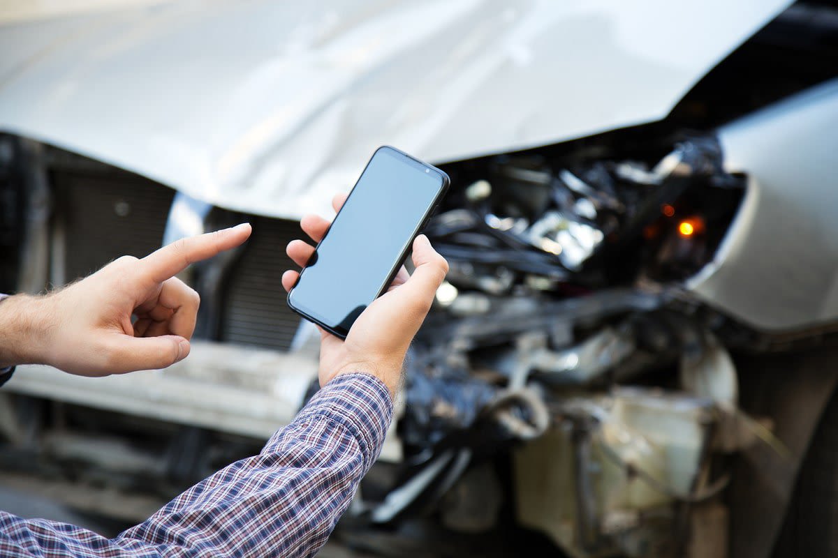 person taking photo of car after an accident