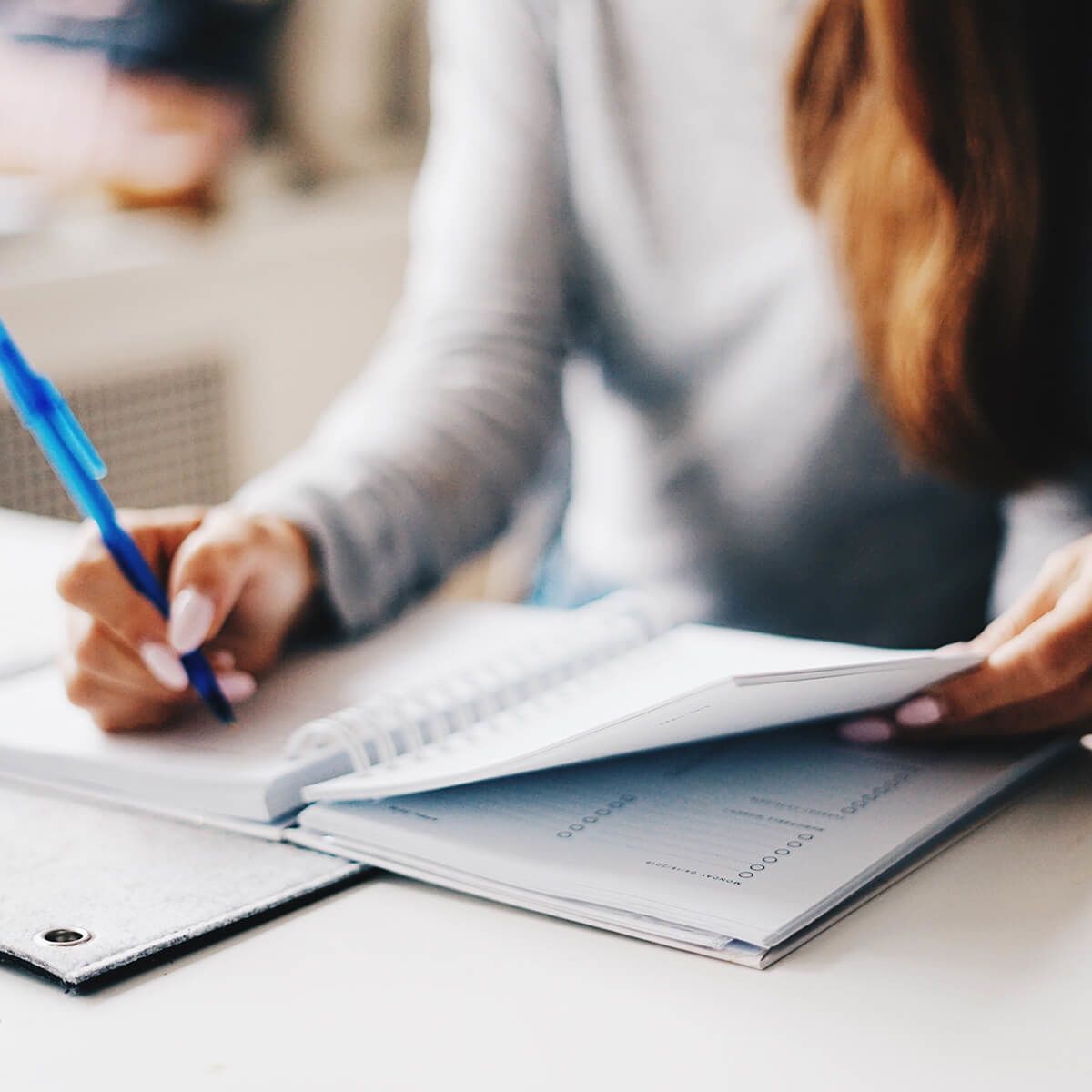 Woman writing in planner