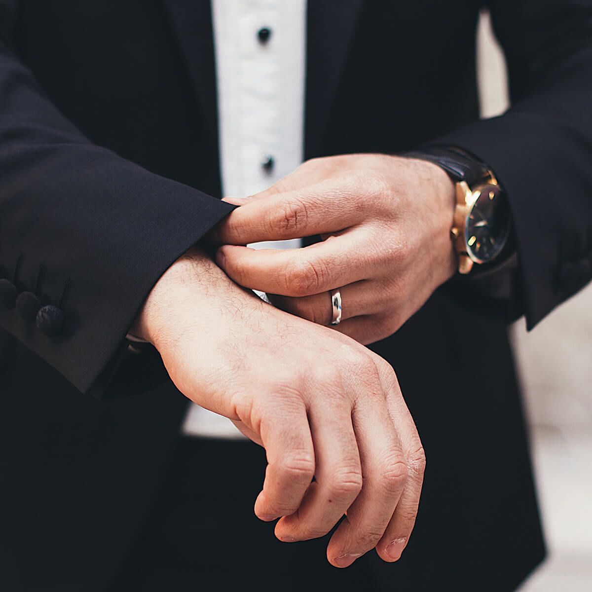 Man in suit adjusting his cuffs
