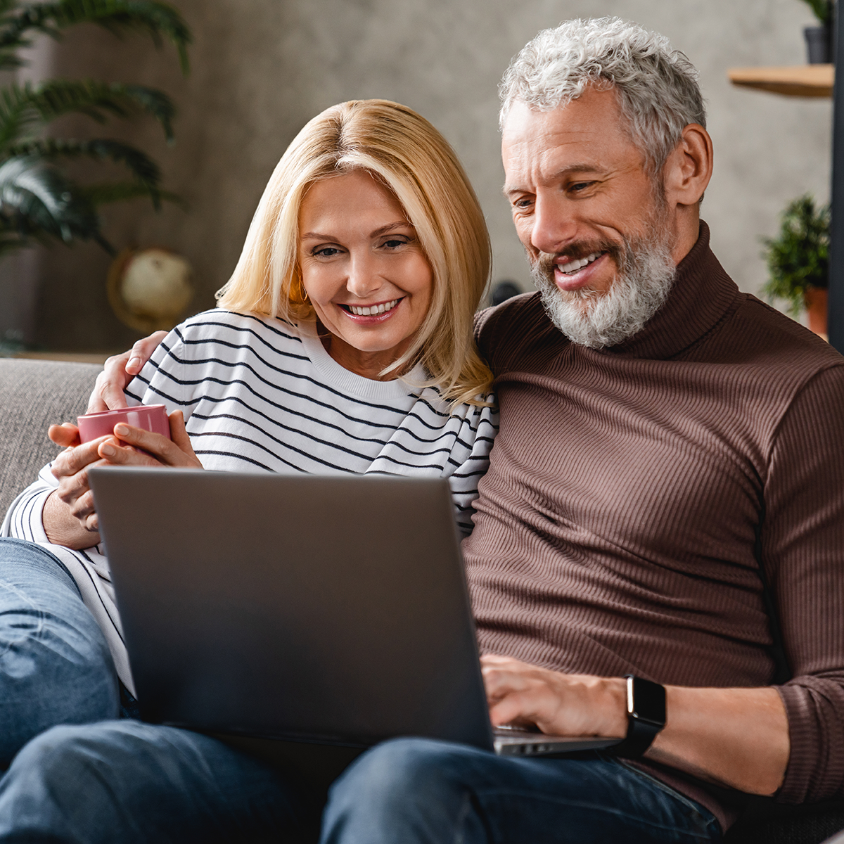 Beautiful middle aged couple using laptop and smiling