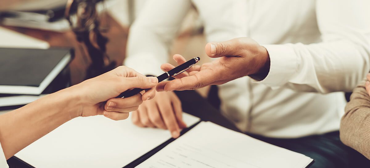 Woman handing over a pen to a businessman