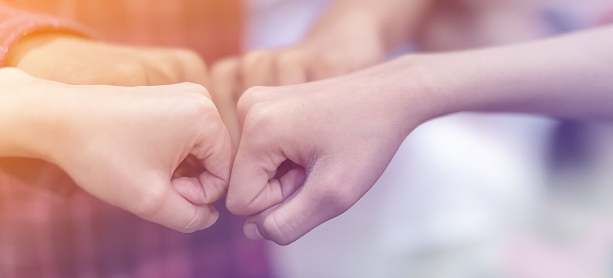 Hands fist bumping symbolizing teamwork