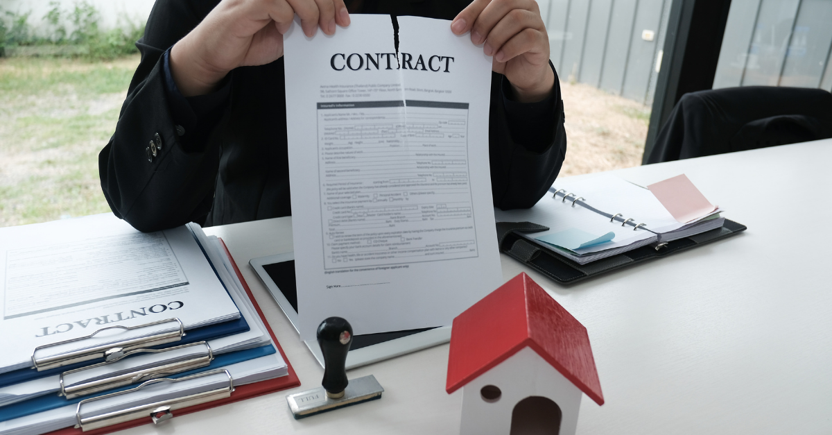 A man sitting at a table ripping up a contract