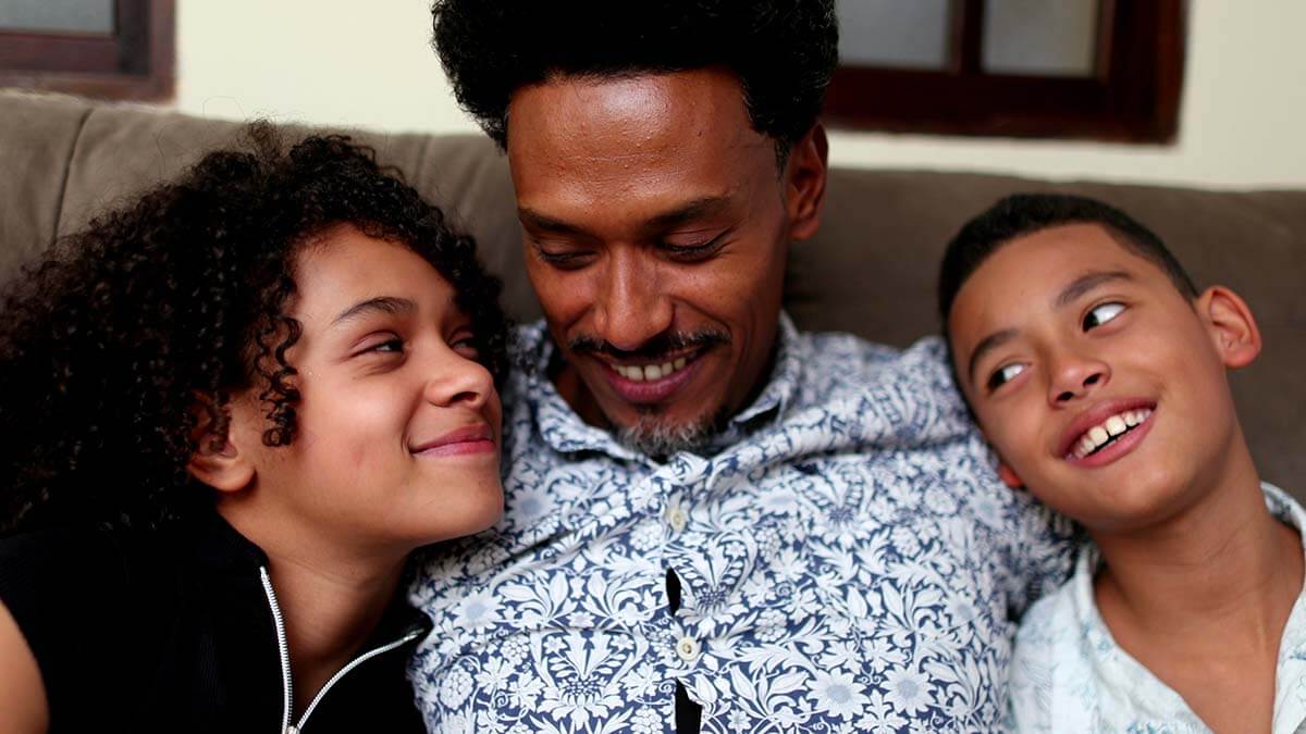 a father laughing with his two kids