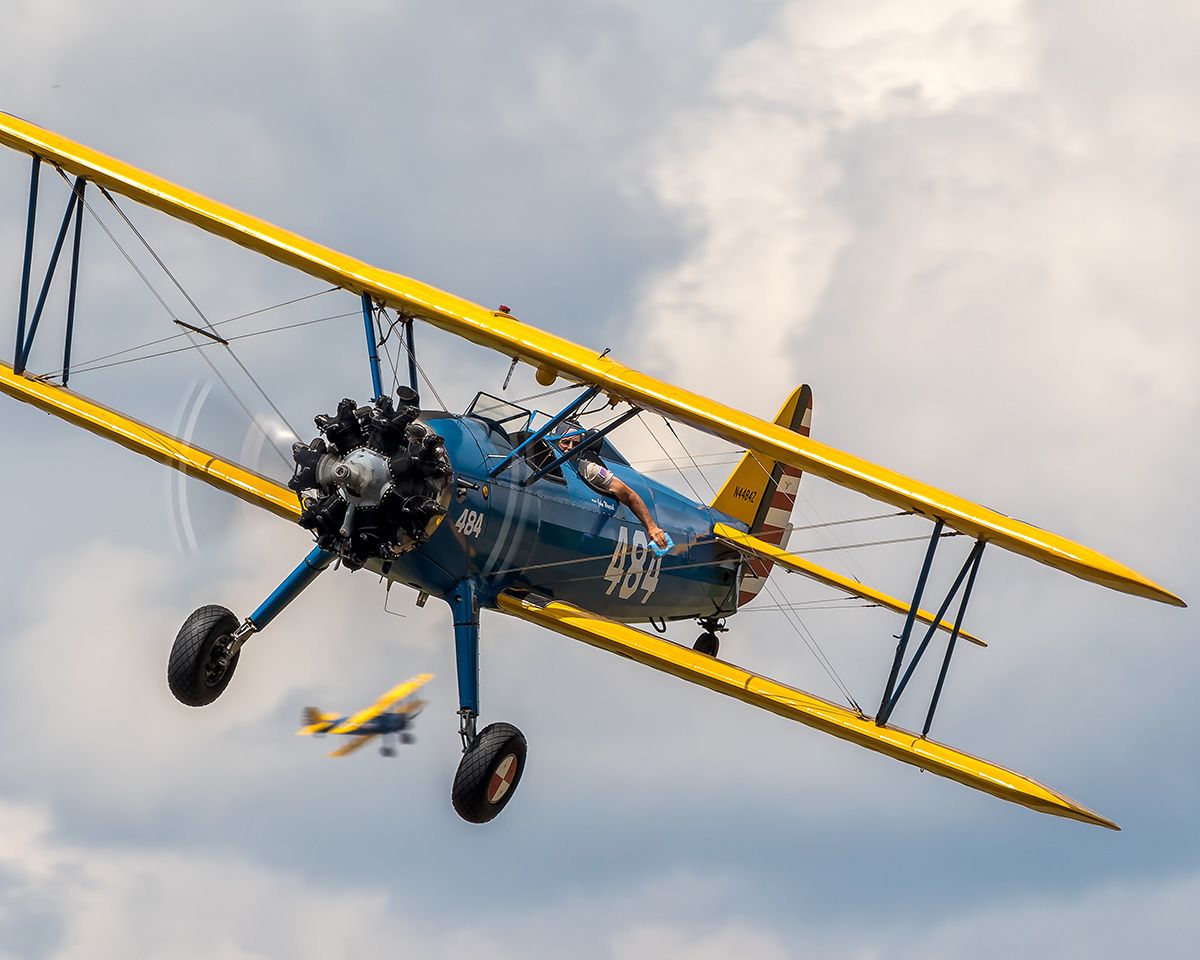 Blue and yellow plane flying through the air.