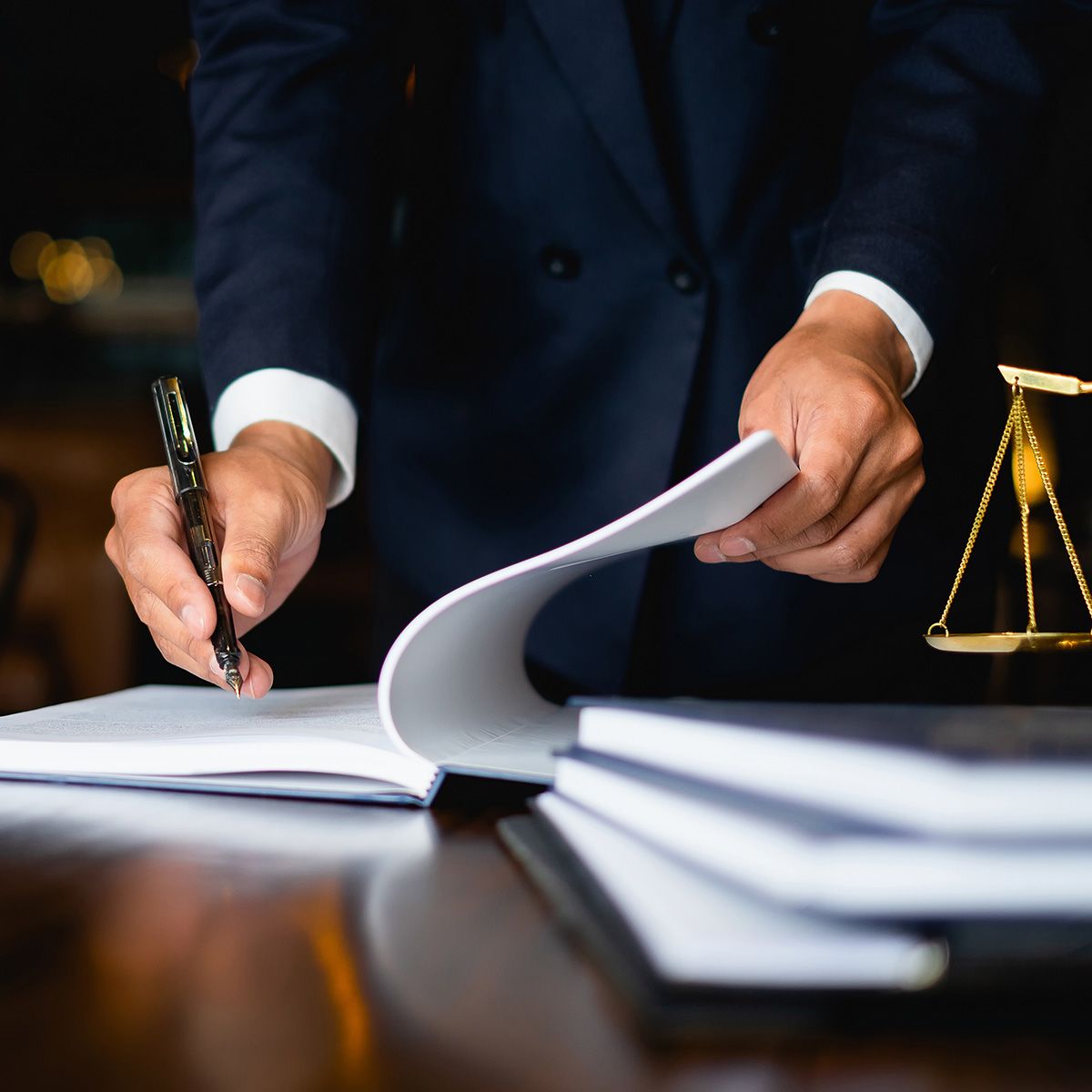 An attorney writing in his book at his desk.