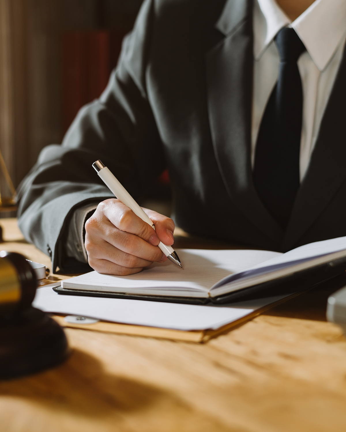 An attorney writing notes at his desk.