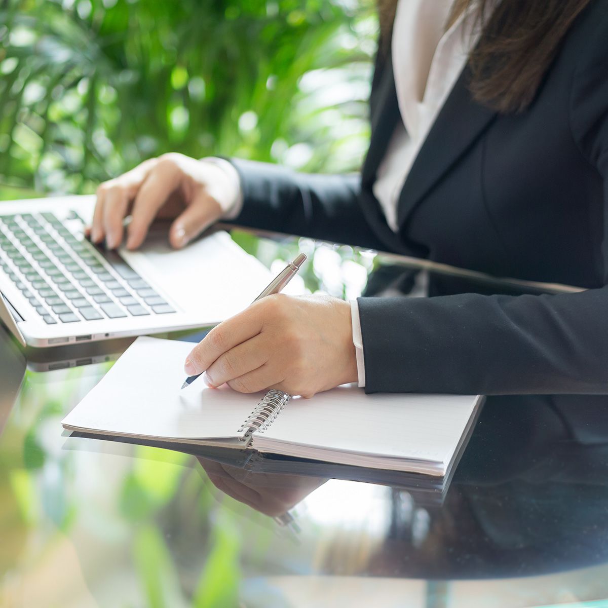 A female attorney writing at her desk while working