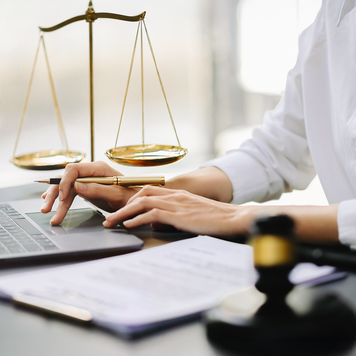 A female attorney tying at her desk
