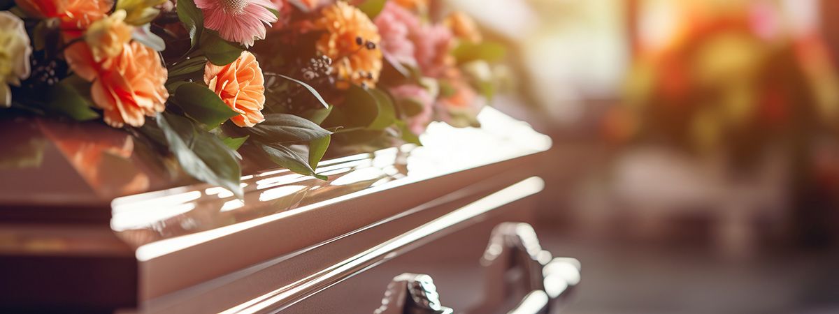 A coffin with flowers on it.