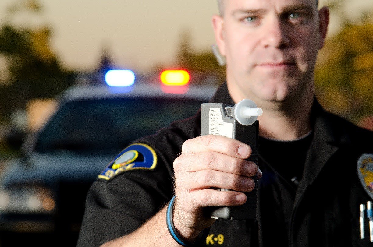 Cop Holding up Breathalizer
