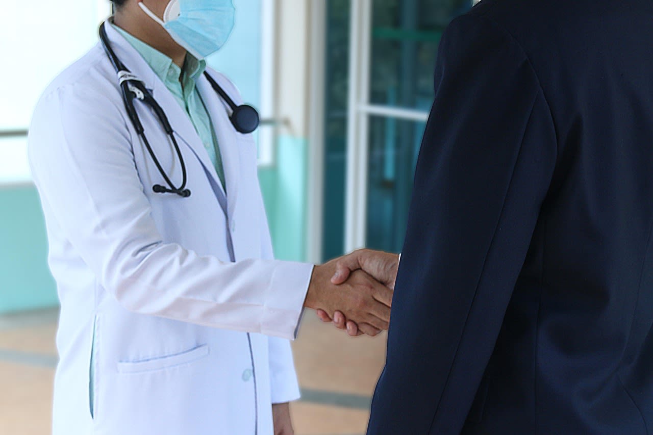 Doctor and adult patient shaking hands during a healthcare planning discussion