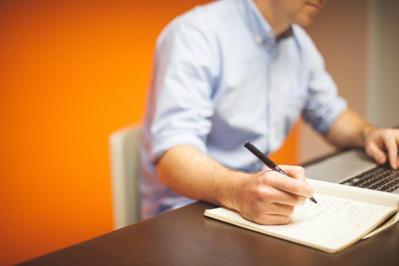 Man Writing on a Notebook