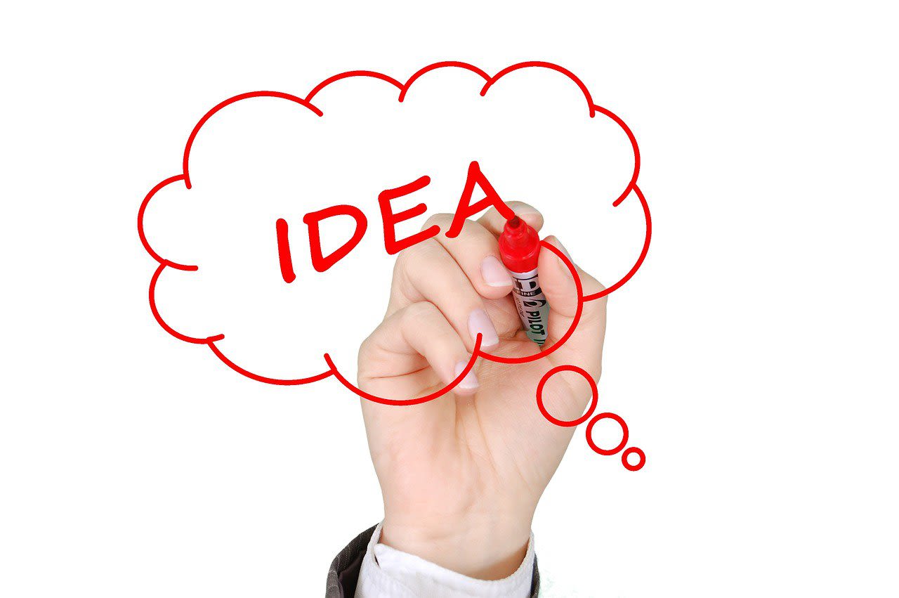 Person writing the word "Idea"