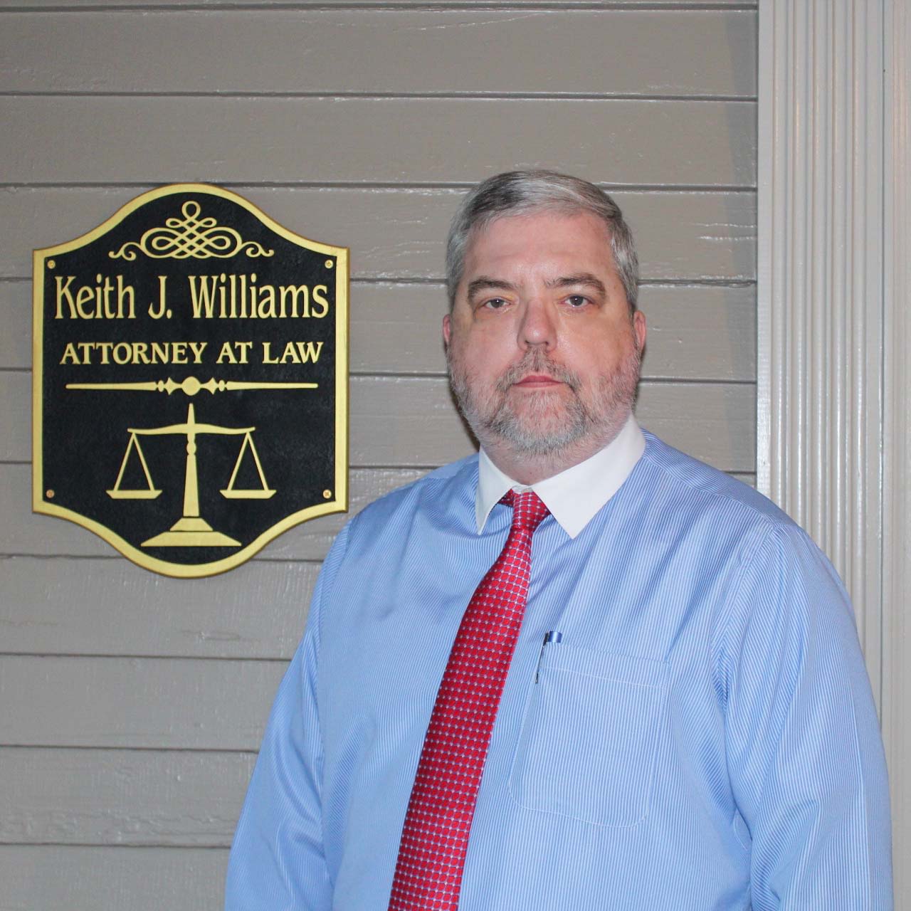 Attorney Keith J. Williams in front of his office sign