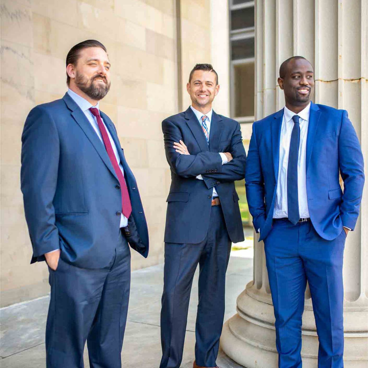 Three attorneys standing next to a court house