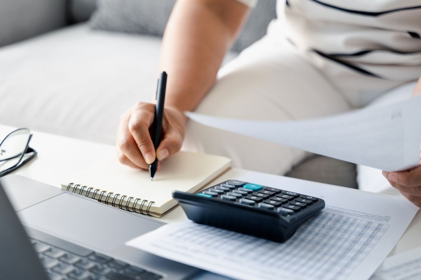 Writing on notepad next to calculator