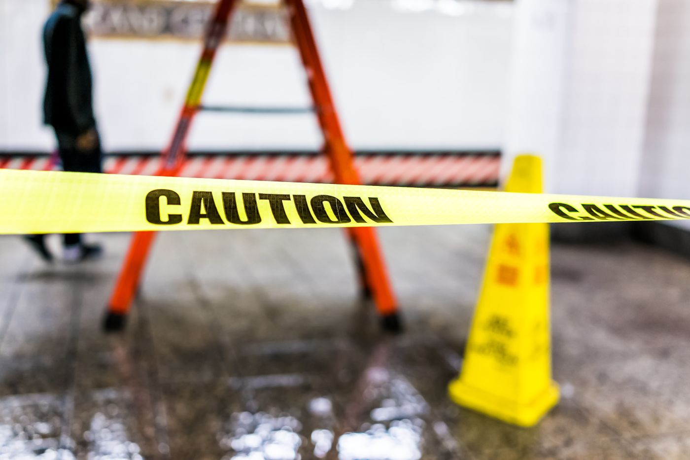Caution tape marking off an icy surface near a caution cone