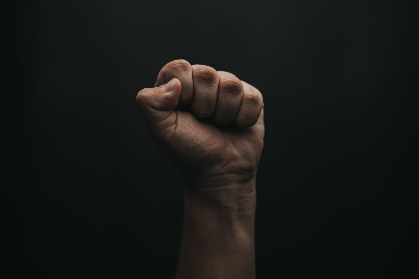 Hand balled in a fist on black background