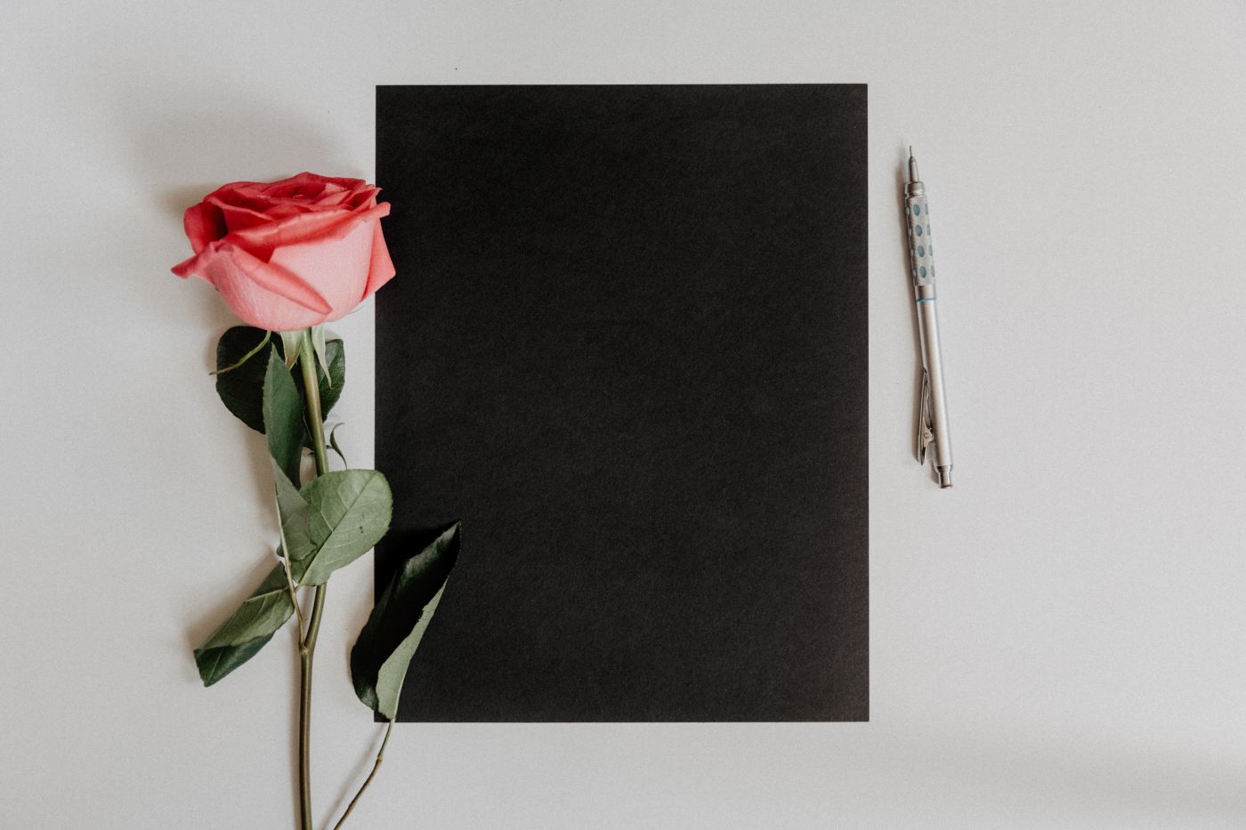 rose lying next to notepad
