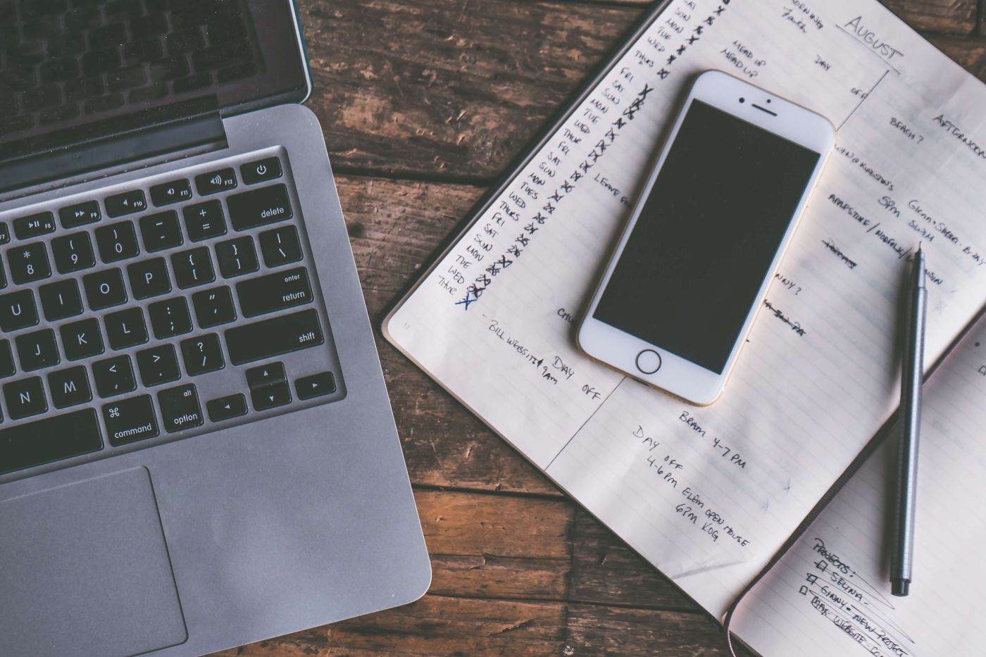 Laptop_on_desk_with_notebook_planner_and_cellphone_and_pen_on_top.jpg