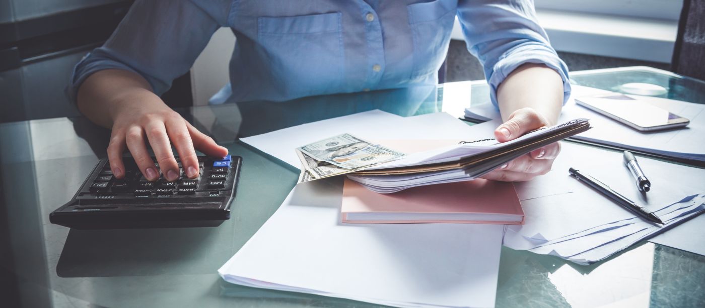 Man holding notebook and using calculator