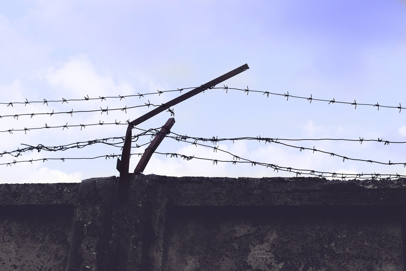Bent barbed wire fence