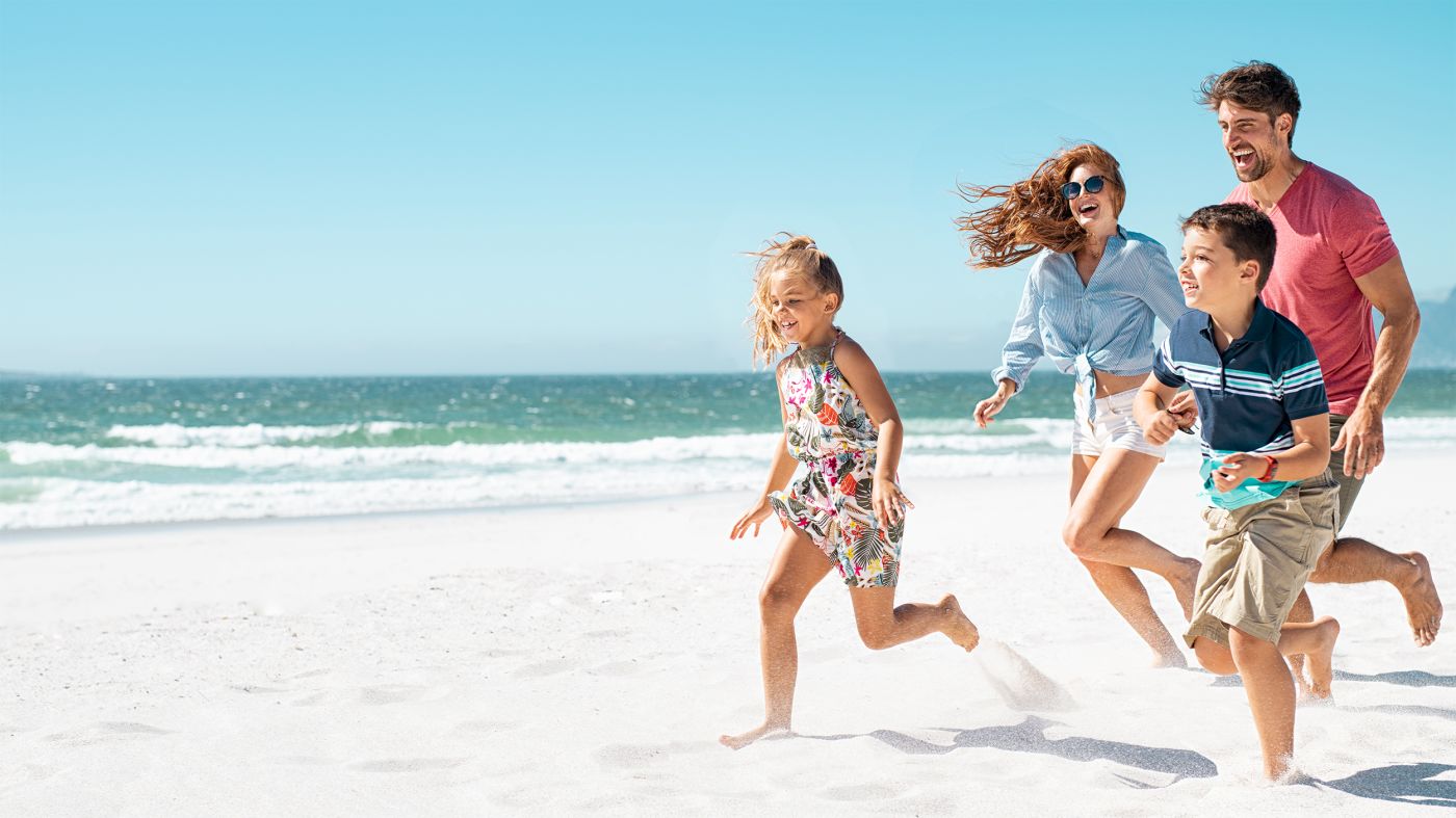 Family smiling and running at the beach