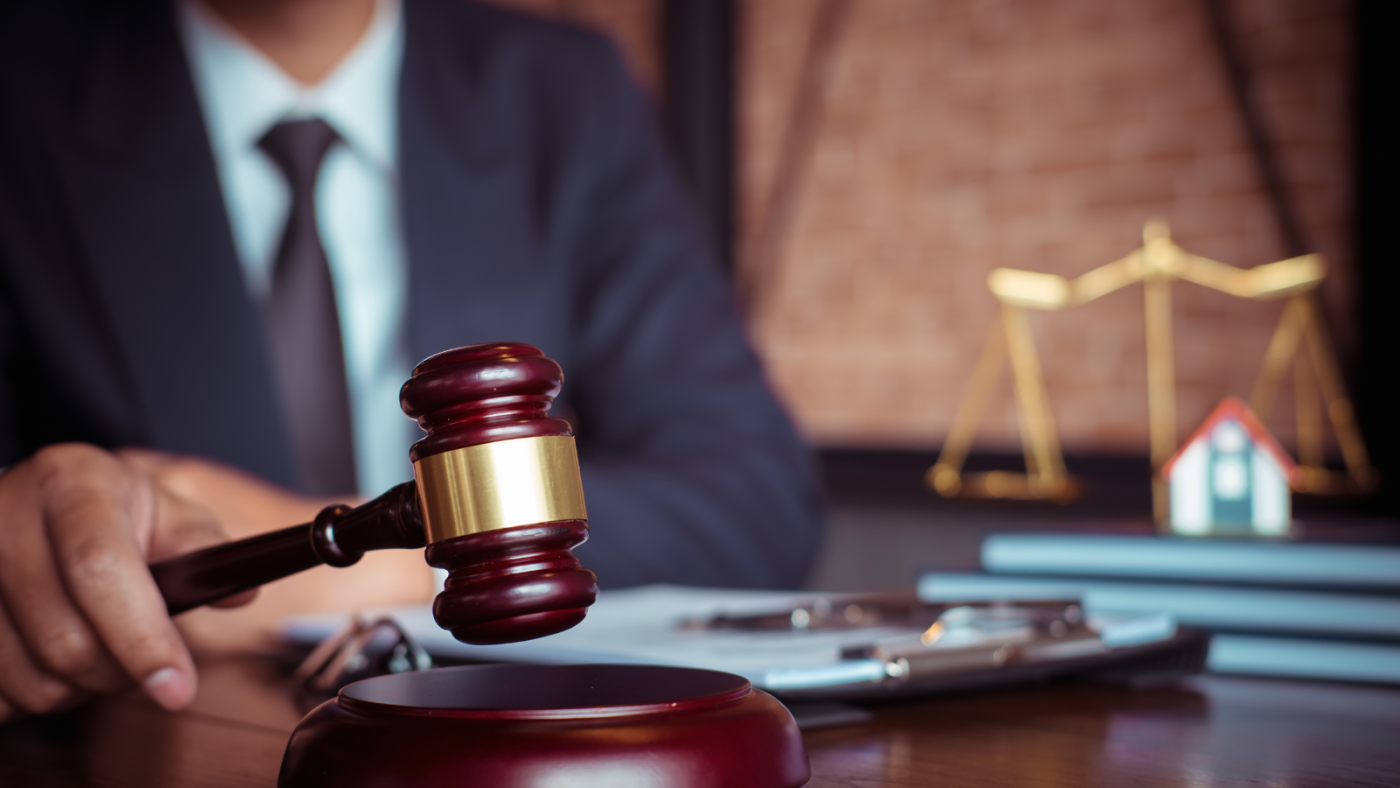 Attorney holding a gavel near scales of justice