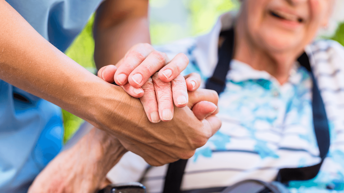 Nurse consoling senior woman holding her hand